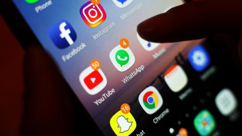 Icons of social media apps, including Facebook, Instagram, YouTube and WhatsApp, displayed on a mobile phone screen