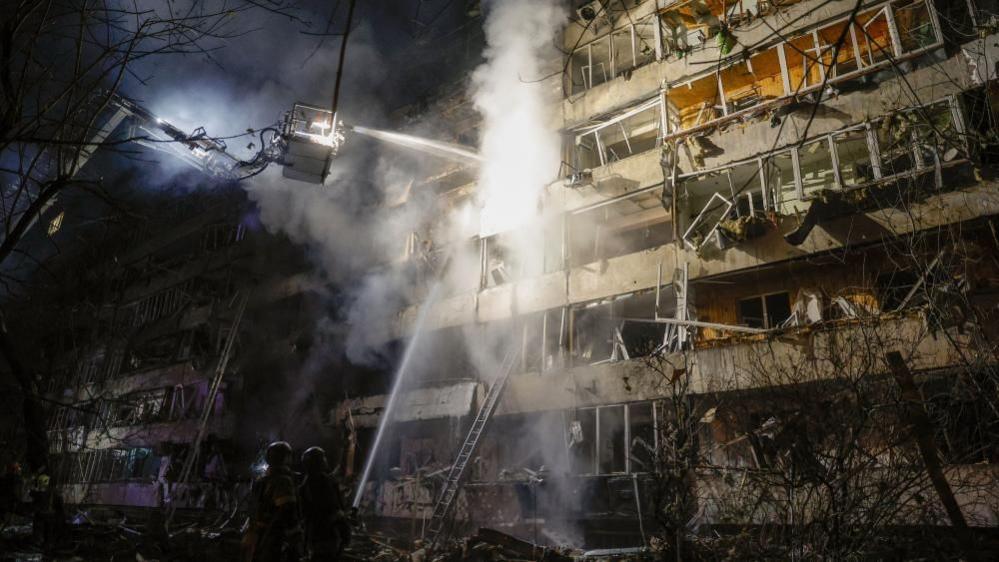 Ukrainian rescuers at a damaged residential building