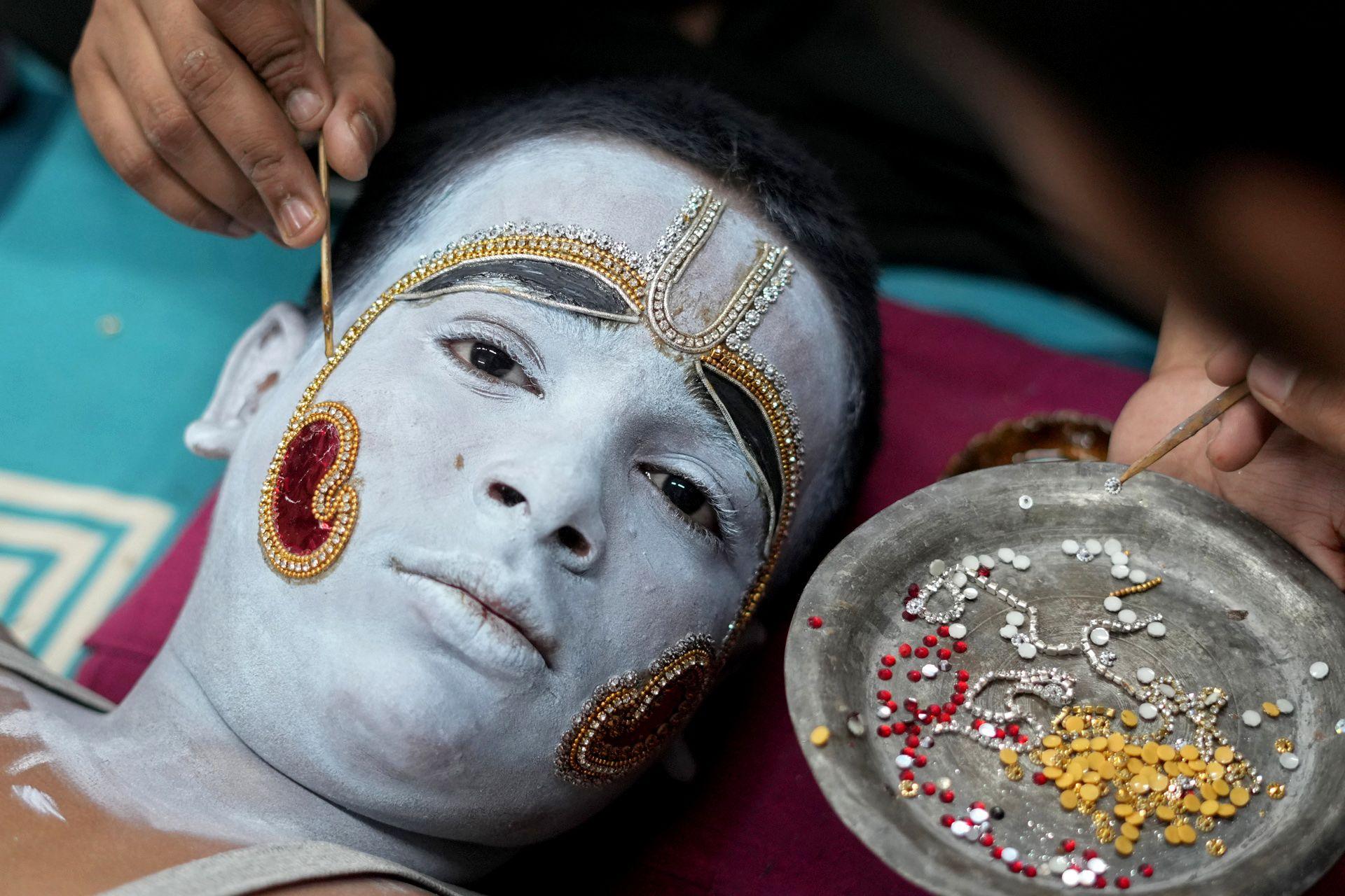 People preparing a painted performer for Dussehra in Uttar Pradesh